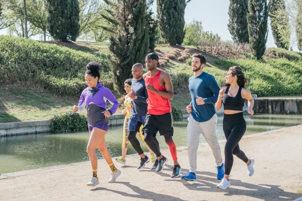 A group of runners jogging casually in a lush tropical park.