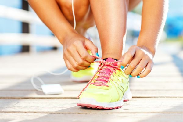 Close-up of a runner tying their shoes.